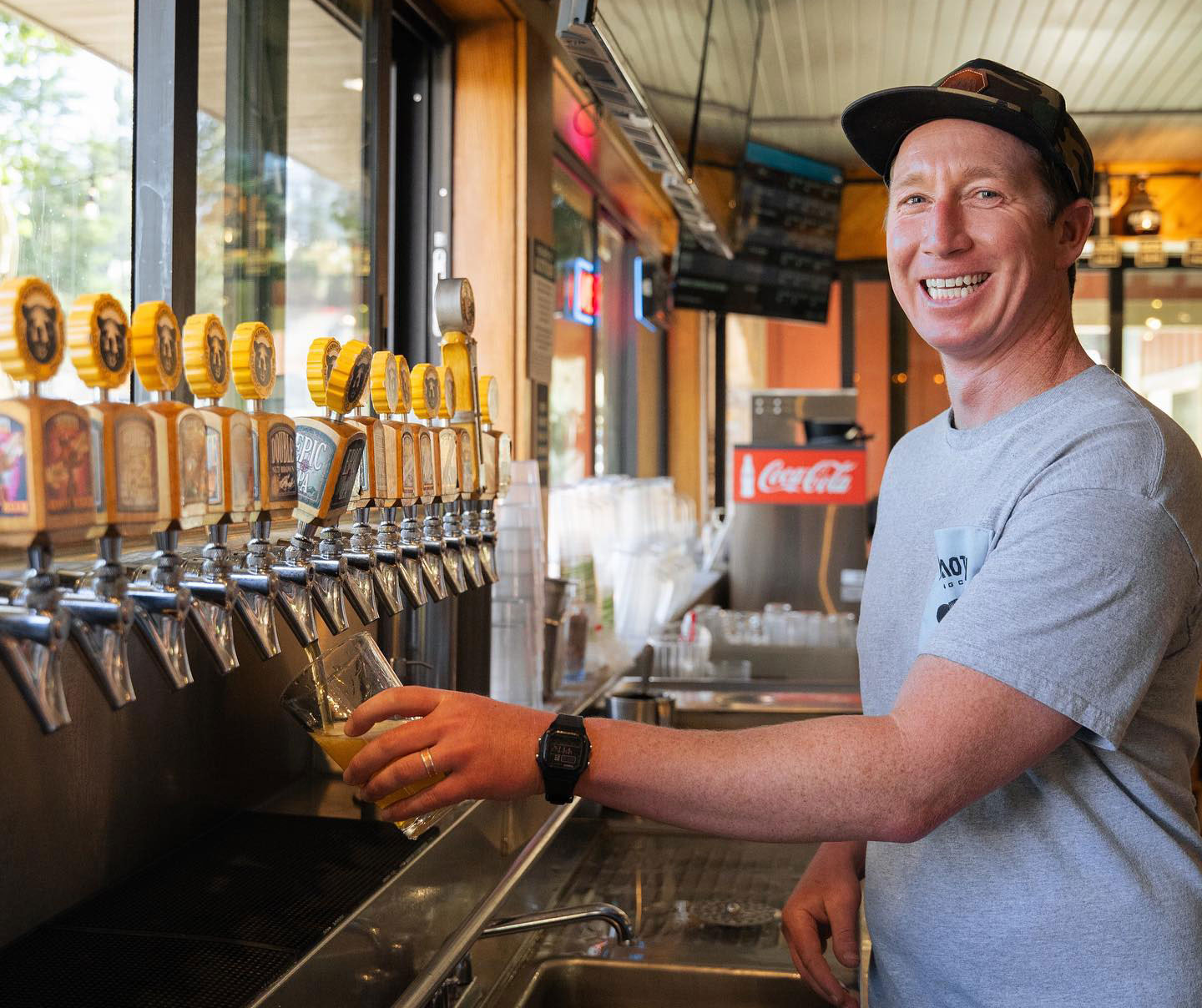 Bartender pouring a beer at a row of taps at MBC